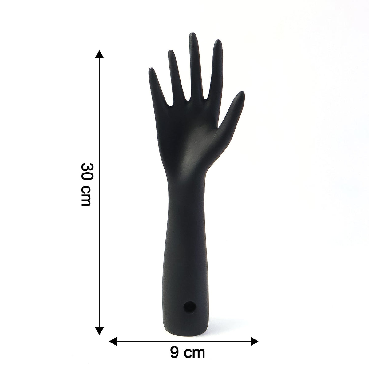Black hand jewelry display stand placed on shelf for accessories